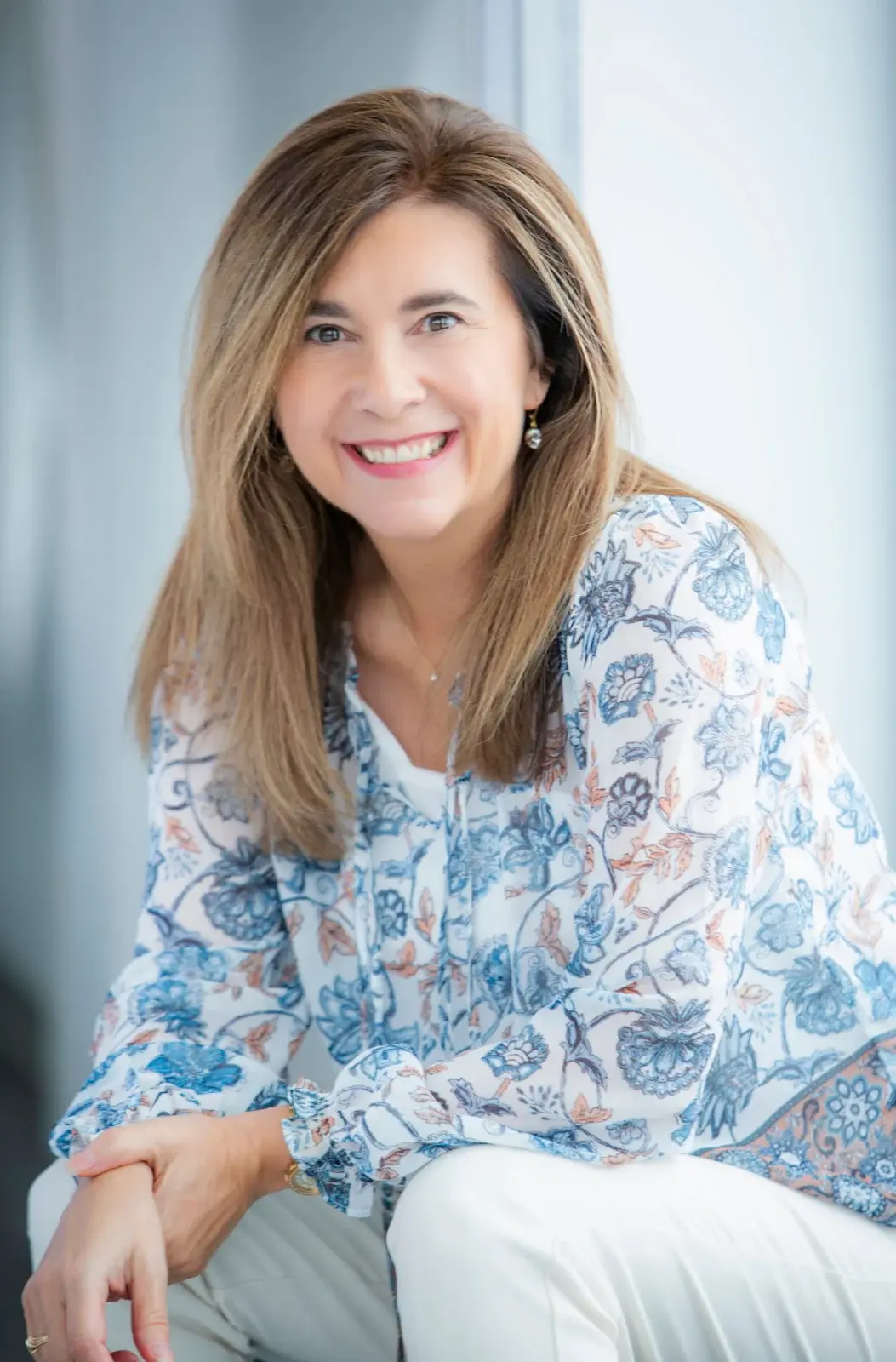 Portrait de Johanne Côté assise, chemisier fleuri bleu