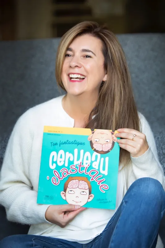 Johanne Côté riant, tenant le livre Ton fantastique cerveau élastique